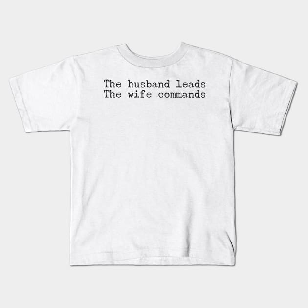 The husband leads. The wife commands. Kids T-Shirt by mike11209